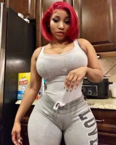 Curvy woman with red hair in tight loungewear posing in kitchen – Cherry, adult phone chat girl in Liverpool.