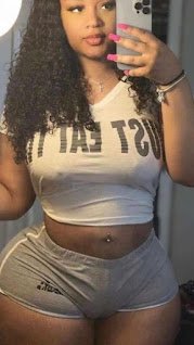 Thick woman in “Just Eat It” crop top and grey shorts taking mirror selfie, curvy body and soft curls – Savvy Lane, UK adult phone chat girl