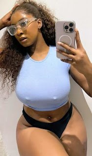 Curvy woman in blue crop top and glasses taking mirror selfie, confident pose and full hips – Jada Knox, UK adult chat model