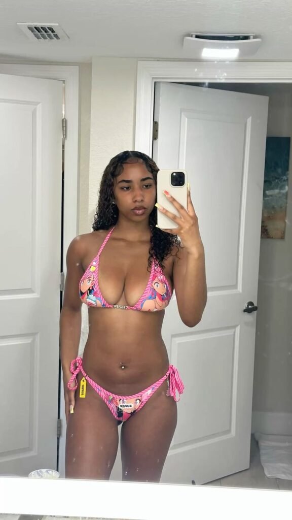 Caribbean girl in pink anime bikini taking mirror selfie, seductive pose, adult phone chat fantasy style.