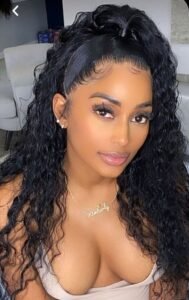 Gorgeous woman with curly hair and deep cleavage posing indoors – adult phone chat model Birmingham UK.