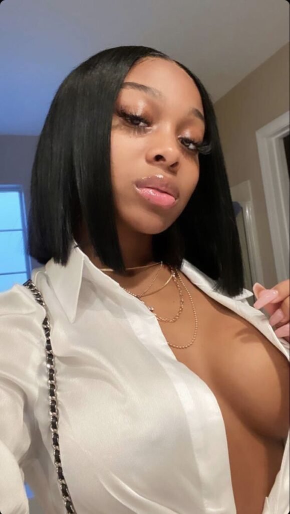 Confident Black woman in satin shirt showing cleavage – adult phone chat in London.