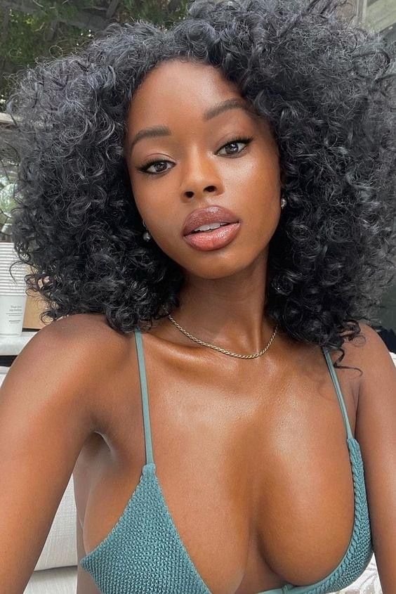 Sapphire Blaze – Busty woman with curly black hair in bikini top posing for phone chat profile