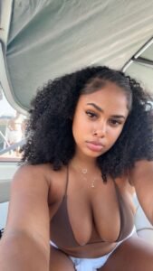 Curvy Caribbean woman with curly hair in bikini on a boat