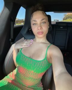 Amara Veyra – exotic green-eyed beauty in a green dress, teasing with a flirty selfie