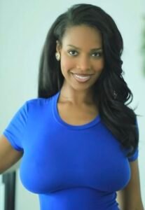 Ebony beauty in a tight blue top smiling seductively