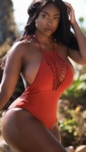 Kiara Flame – Caribbean woman in orange swimsuit posing seductively in Manchester UK