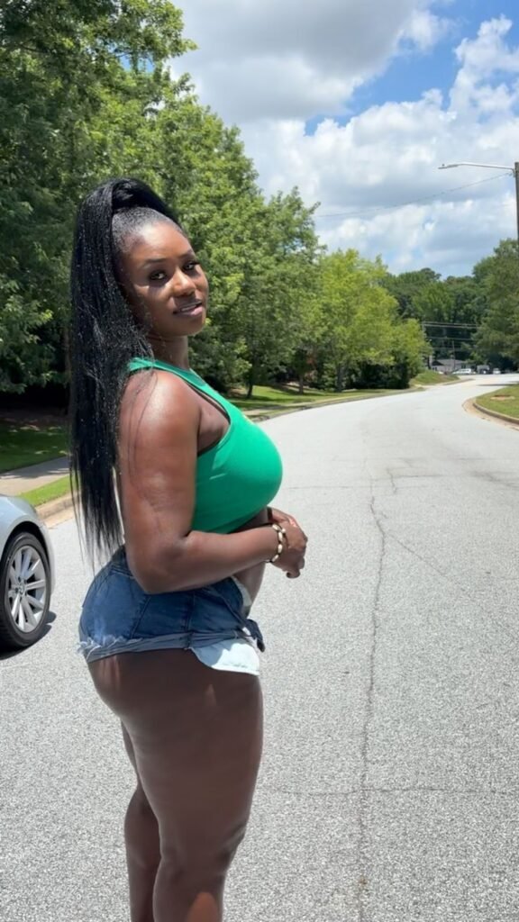 Tiana Blaze – curvy Caribbean woman in green top and denim shorts posing seductively outdoors in Birmingham UK