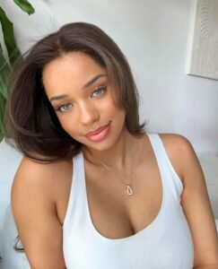 Ebony beauty with hazel eyes smiling in white top