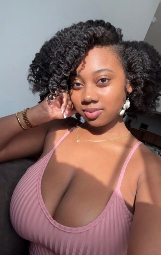 Busty Afro-Caribbean beauty Teyah Rose in pink top teasing for soft phone sex in the UK