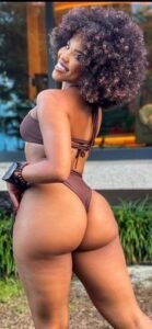 Arielle Vibe – Caribbean woman in brown bikini smiling over her shoulder in Manchester UK