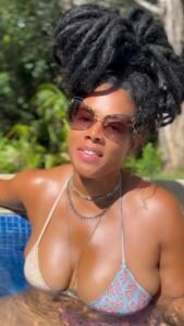 Zahara Luxe – Caribbean woman in bikini with natural dreadlocks relaxing in a pool in Birmingham UK