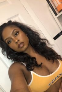 Amara Gold – Curvy black woman in yellow bra posing seductively for phone chat promo