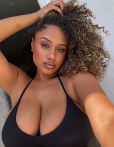 Curvy Caribbean girl Tiana Flame in a black top posing for phone sex chat in Manchester UK