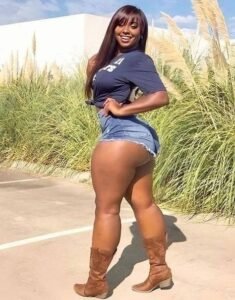 Savannah Blaze – Curvy Caribbean woman in denim shorts and boots posing outdoors in London UK