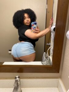 Kiana Frost – Curvy Caribbean woman in blue shorts taking a mirror selfie in London UK
