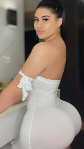 Latina goddess in tight white dress posing seductively