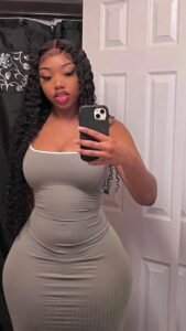 Ebony goddess in fitted grey dress taking mirror selfie