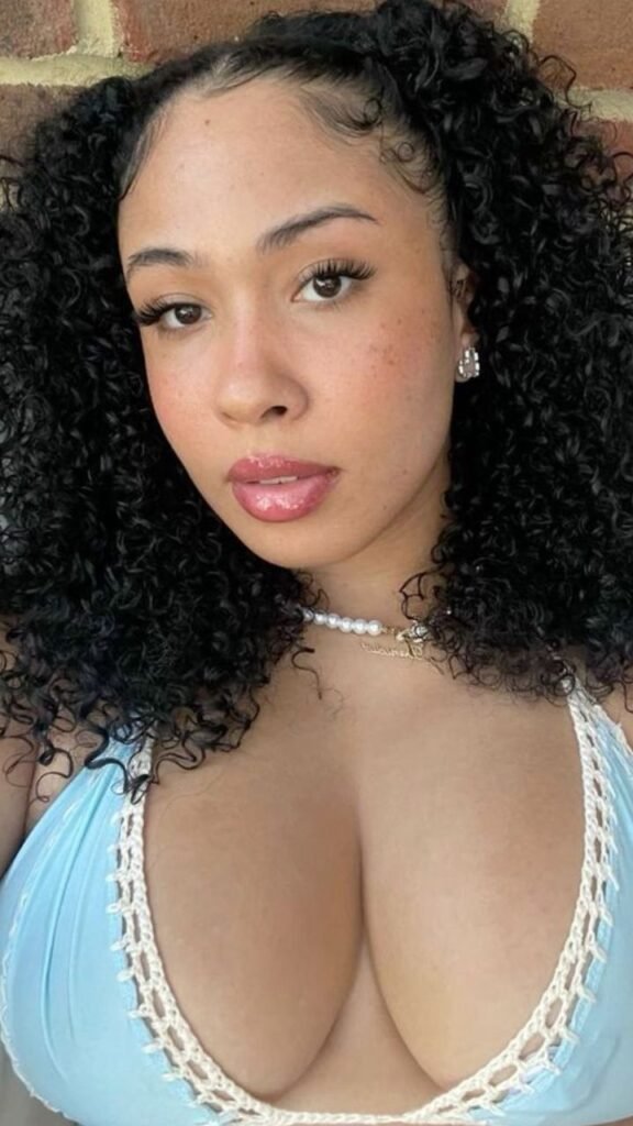 Ebony beauty in blue crochet bikini top posing outdoors