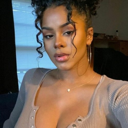 Curly-haired Caribbean model Sade Monroe in low-cut top offering sensual phone chat in the UK