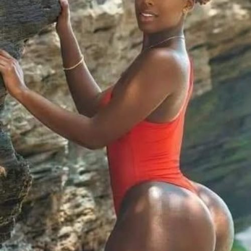 Imani Rose – Curvy Caribbean woman in red swimsuit posing seductively by the rocks in Manchester UK