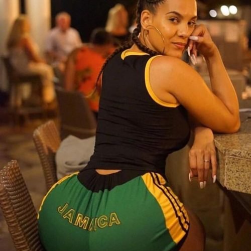 Leilani Jade – Jamaican curvy woman in green and yellow shorts posing at a bar in London UK