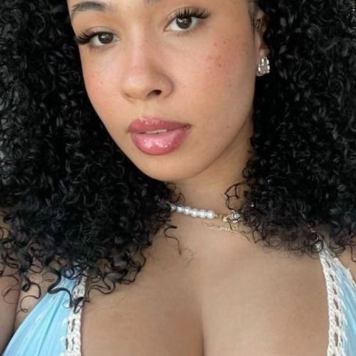 Ebony beauty in blue crochet bikini top posing outdoors