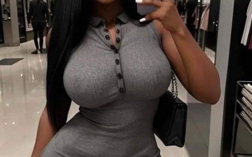 Ebony bombshell in tight grey dress taking mirror selfie