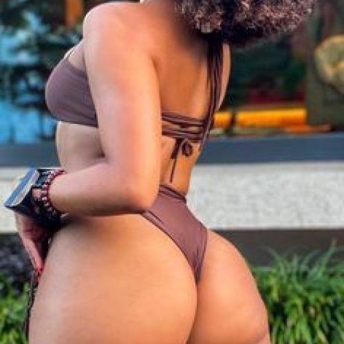 Arielle Vibe – Caribbean woman in brown bikini smiling over her shoulder in Manchester UK
